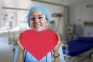 Image of a person in scrubs holding a paper heart